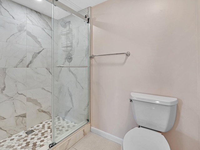 bathroom featuring a shower with door and toilet