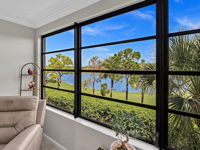 sunroom featuring a water view