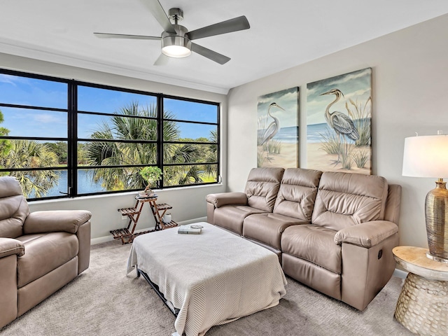 living room featuring light carpet, ceiling fan, and a water view