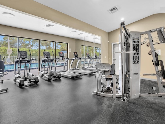 exercise room with a healthy amount of sunlight and vaulted ceiling