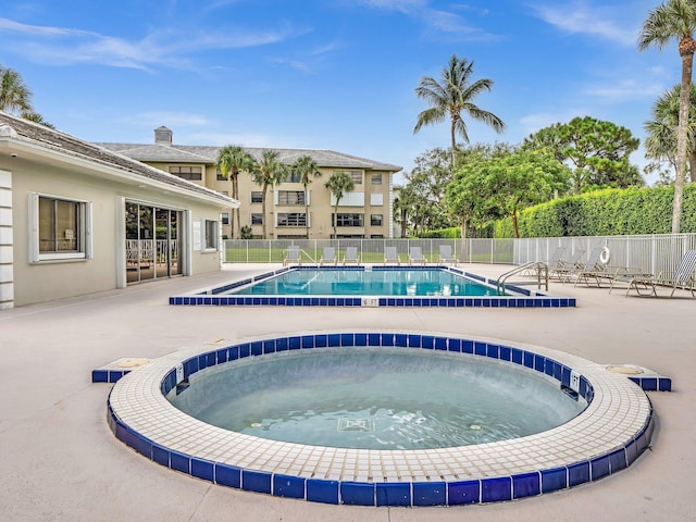 view of swimming pool with a patio and a community hot tub