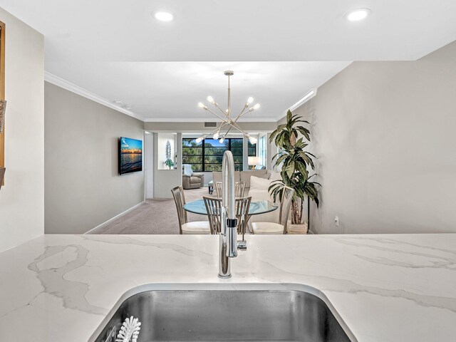 details with hanging light fixtures, a notable chandelier, ornamental molding, and sink