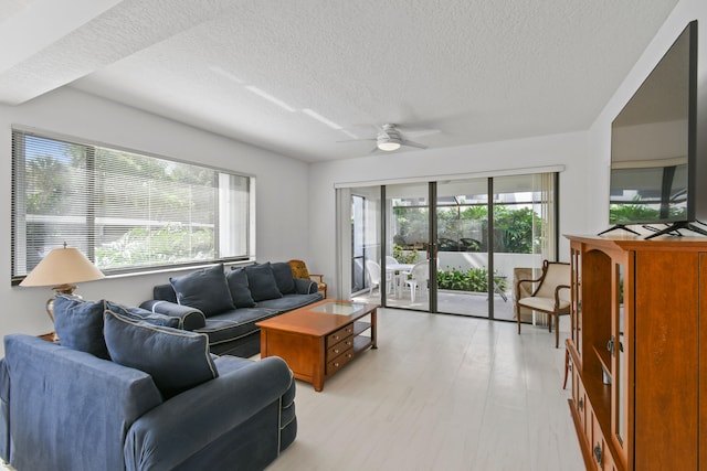 living room with plenty of natural light, a textured ceiling, and ceiling fan