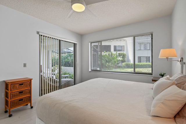 bedroom featuring ceiling fan, access to outside, and a textured ceiling