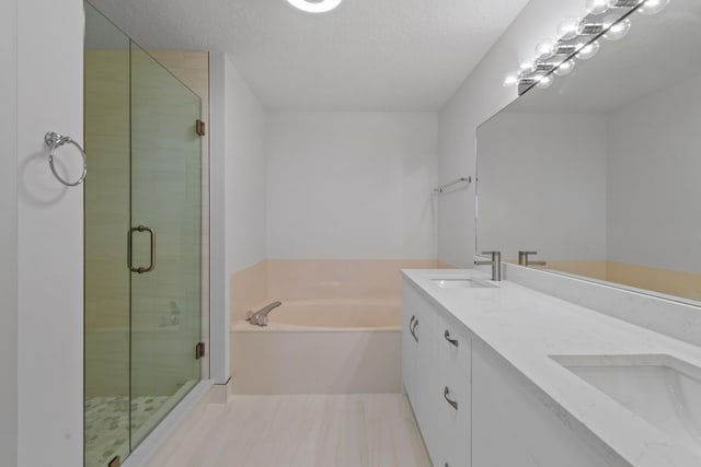 bathroom with plus walk in shower, tile patterned floors, a textured ceiling, and double sink vanity