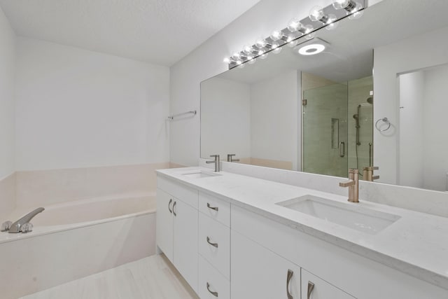 bathroom with independent shower and bath, a textured ceiling, and dual bowl vanity