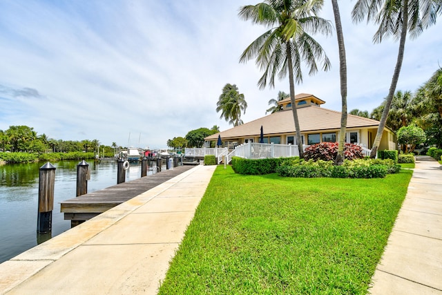 dock area with a water view and a lawn