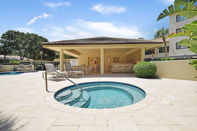 view of swimming pool featuring a patio area and a hot tub