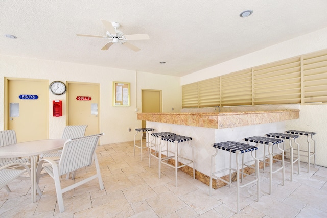 kitchen with a textured ceiling, light tile patterned floors, and ceiling fan