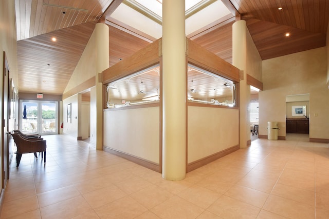 corridor featuring light tile patterned flooring, french doors, wood ceiling, and high vaulted ceiling