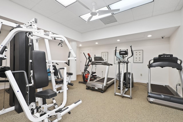 gym with a paneled ceiling and ceiling fan