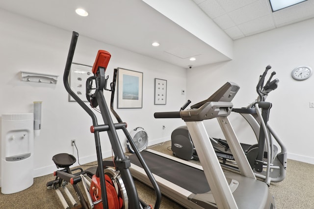 workout area featuring carpet and a drop ceiling