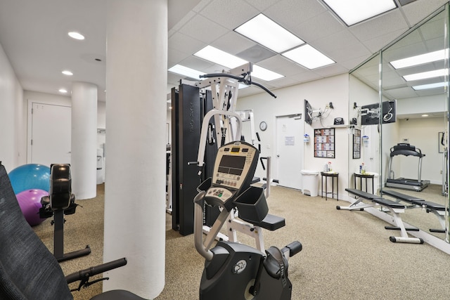 exercise room with carpet floors and a paneled ceiling