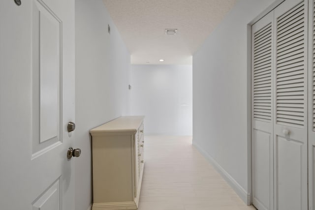 corridor with a textured ceiling