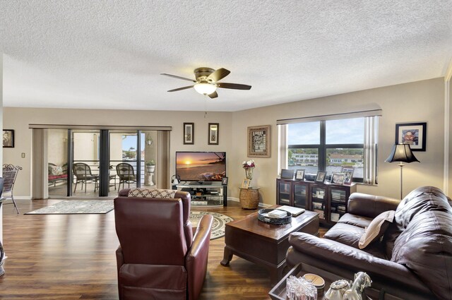 living room featuring dark hardwood / wood-style flooring, a textured ceiling, and ceiling fan