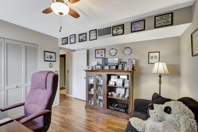 office space with a textured ceiling, ceiling fan, and hardwood / wood-style floors