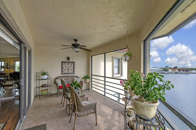 sunroom / solarium with a water view and ceiling fan