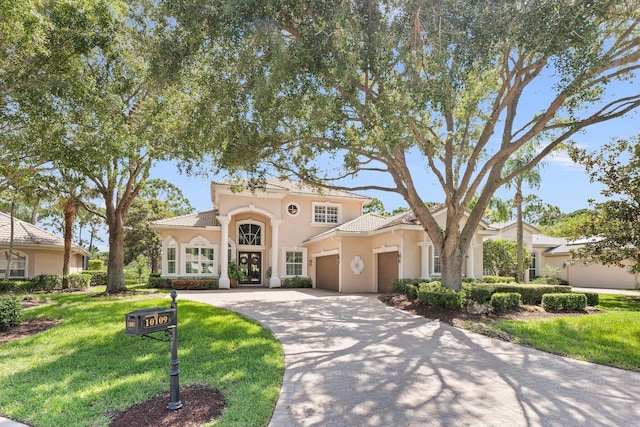 mediterranean / spanish home with a garage and a front yard