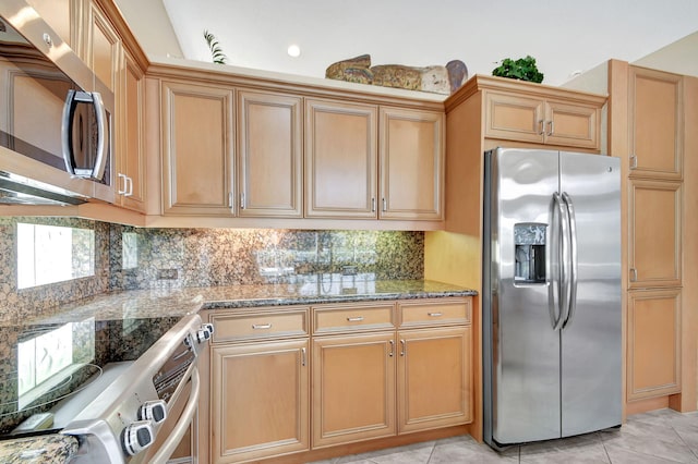 kitchen with light stone counters, light tile patterned floors, decorative backsplash, and stainless steel appliances