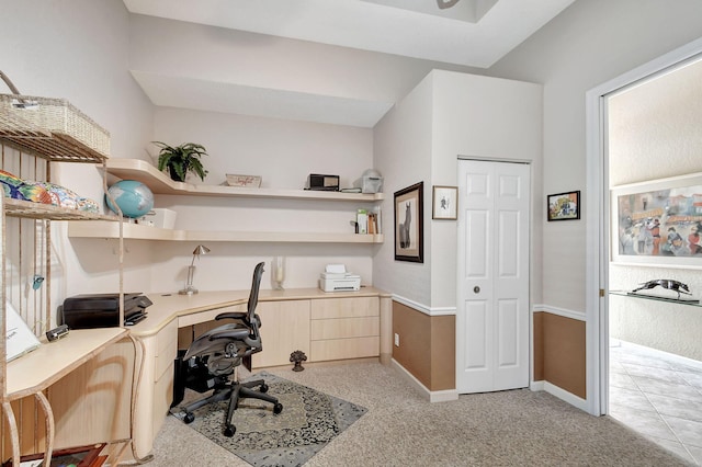 carpeted office space featuring built in desk