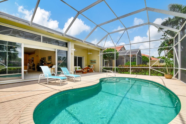 view of swimming pool featuring a lanai, a patio, and ceiling fan