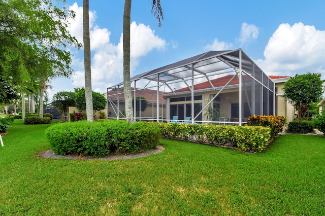 back of property featuring a lanai and a lawn