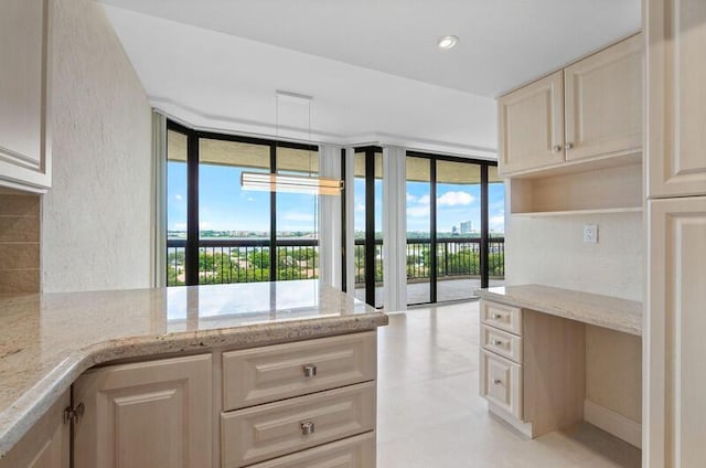 kitchen featuring expansive windows, light stone counters, and recessed lighting