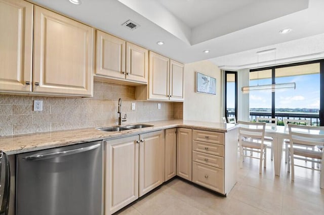 kitchen featuring light stone counters, tasteful backsplash, visible vents, stainless steel dishwasher, and a sink