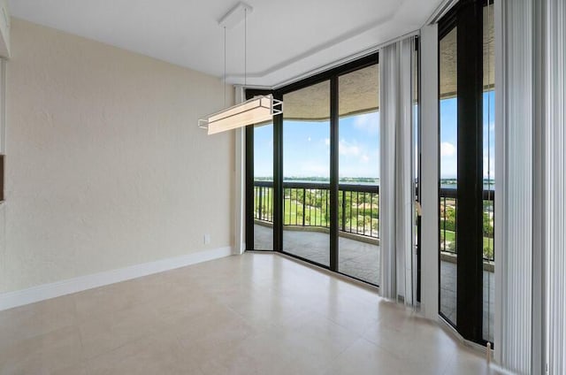 empty room with expansive windows and baseboards