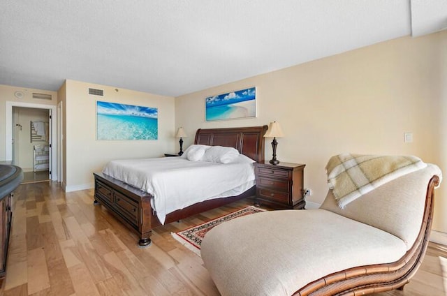 bedroom featuring light wood-style floors, baseboards, and visible vents