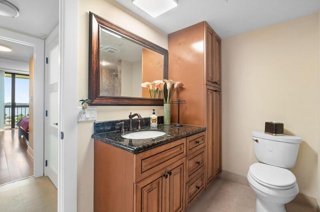 bathroom with toilet, vanity, and baseboards