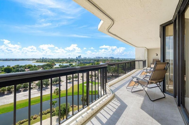 balcony featuring a water view and a city view