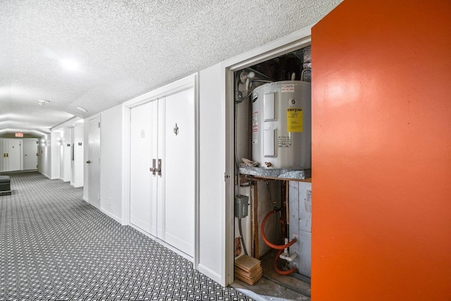 hall featuring carpet, a textured ceiling, and electric water heater