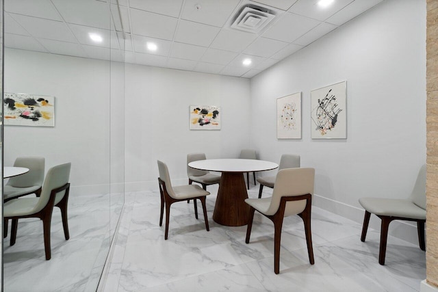 dining room featuring marble finish floor, visible vents, a drop ceiling, and baseboards