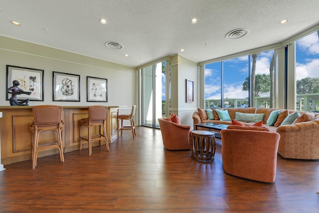 living area featuring expansive windows, dark wood-type flooring, and a textured ceiling