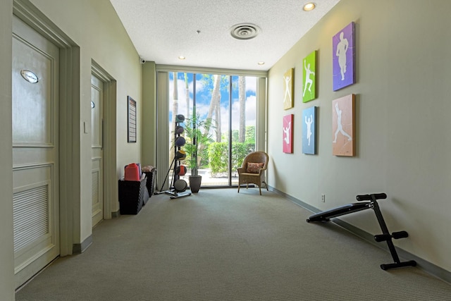 unfurnished room featuring light carpet, expansive windows, visible vents, and a textured ceiling