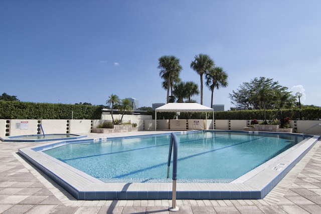 pool with a hot tub and fence