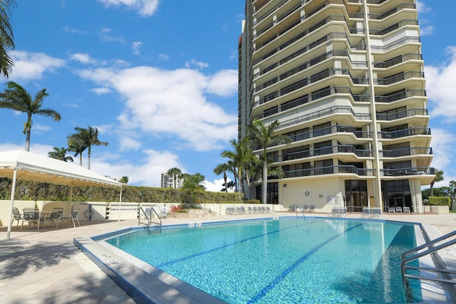 community pool featuring fence and a patio