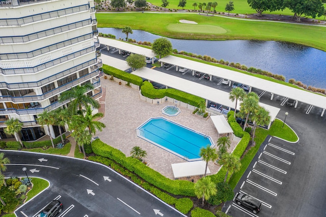 drone / aerial view with a water view and golf course view