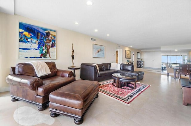 living area with recessed lighting, visible vents, and baseboards