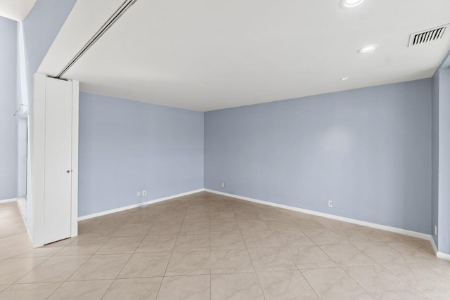 empty room with recessed lighting, visible vents, and baseboards