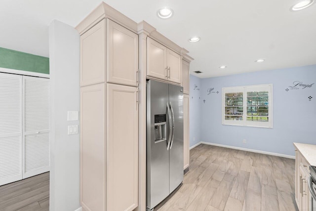 kitchen with light wood-style flooring, recessed lighting, light countertops, and stainless steel fridge with ice dispenser