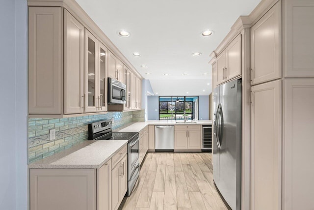 kitchen with stainless steel appliances, glass insert cabinets, backsplash, and a sink