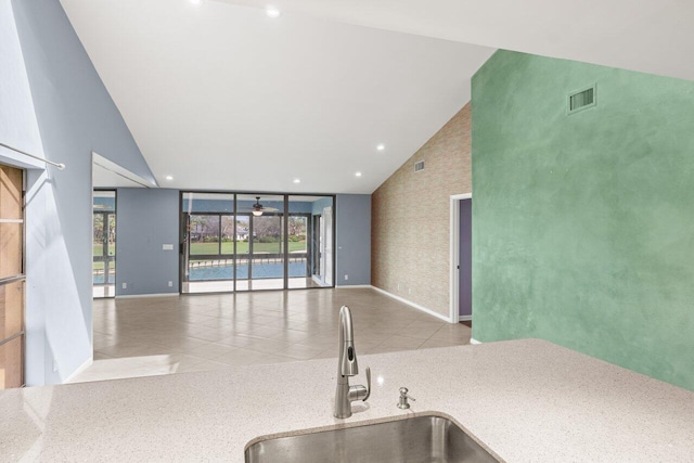 kitchen with a healthy amount of sunlight, light tile patterned floors, open floor plan, and a sink