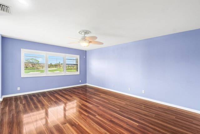 unfurnished room featuring dark wood-style floors, visible vents, baseboards, and a ceiling fan