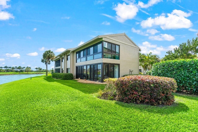 back of property featuring a water view and a yard