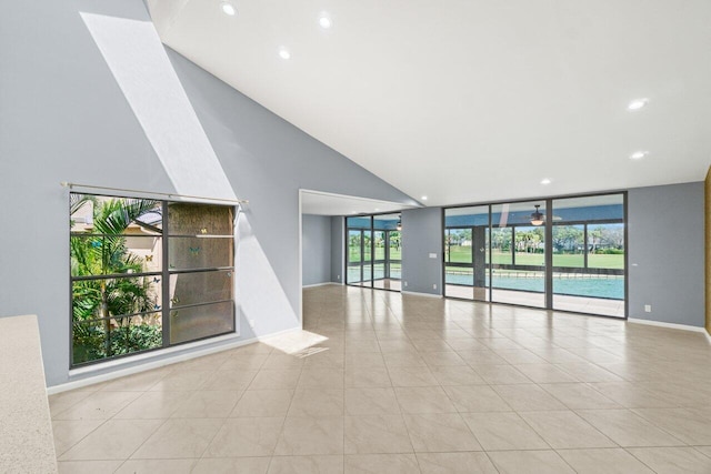 unfurnished living room with light tile patterned floors, expansive windows, and baseboards