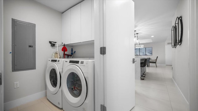 clothes washing area with cabinets, washing machine and clothes dryer, light tile patterned floors, and electric panel