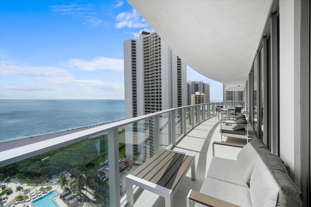 balcony featuring a beach view and a water view