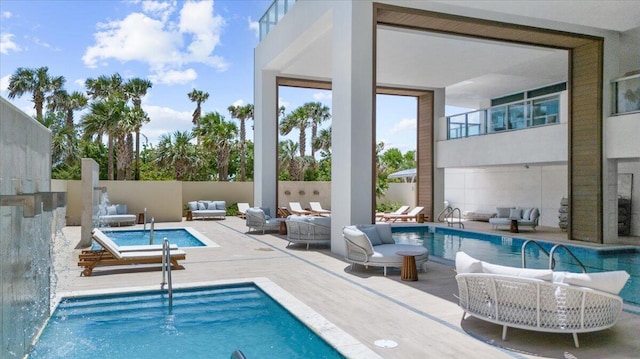 view of swimming pool with pool water feature, an outdoor living space, and a patio